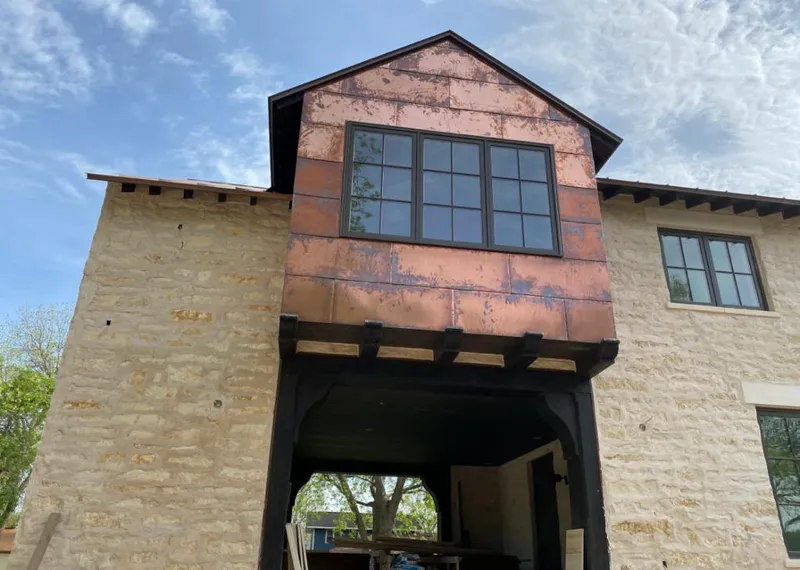 Copper metal panel facade on a stone building for Skylight Installation in La Follette